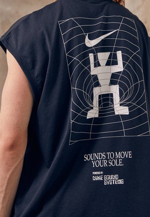 Mouwloos zwart shirt met een witte abstracte figuur onder de Nike-swoosh, rasterontwerp en de tekst "Sounds to move your sole" op de achterkant.
