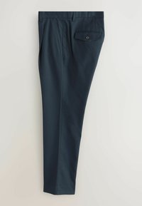 Pantalon bleu marine ajusté avec plis sur le devant, poches latérales, passants de ceinture et une poche à rabat boutonnée à l’arrière droite.