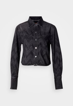 Czarna skórzana kurtka z wycięciem w stylu denim z wzorem chevron, z zapięciem na zatrzaski, długimi rękawami i wyraźnie uformowanym kołnierzem. Teksturowane wykończenie.