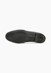 Semelle de chaussure noire en caoutchouc texturé, avec un logo circulaire et une finition antidérapante. Le bord supérieur lisse complète le design.