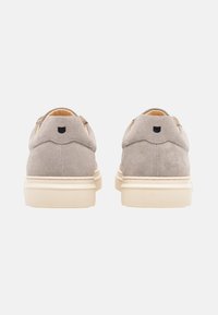 Scarpe in suede grigio con suola in gomma beige, forma arrotondata e dettagli cuciti. Presentano un logo nero sul retro.