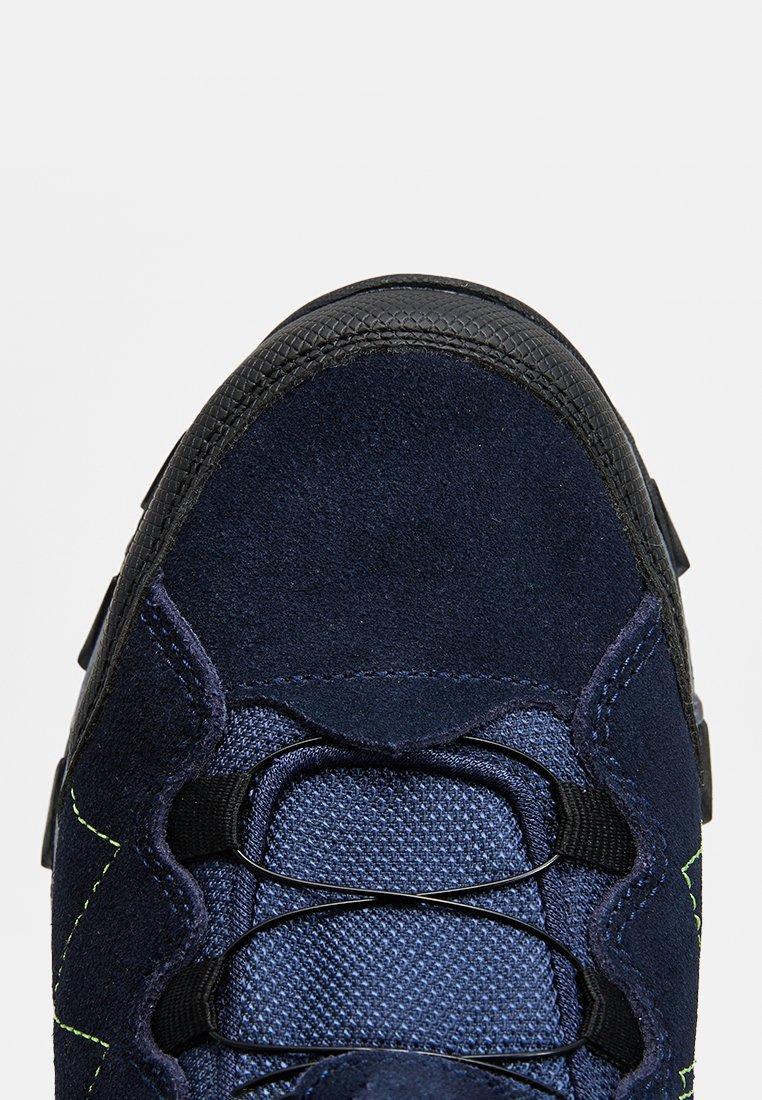 Navyblauer Wildledersportschuh mit schwarzer Gummisohle, strukturiertem Mesh-Zungenbereich und kontrastierenden grünen Nähten an den Seiten.