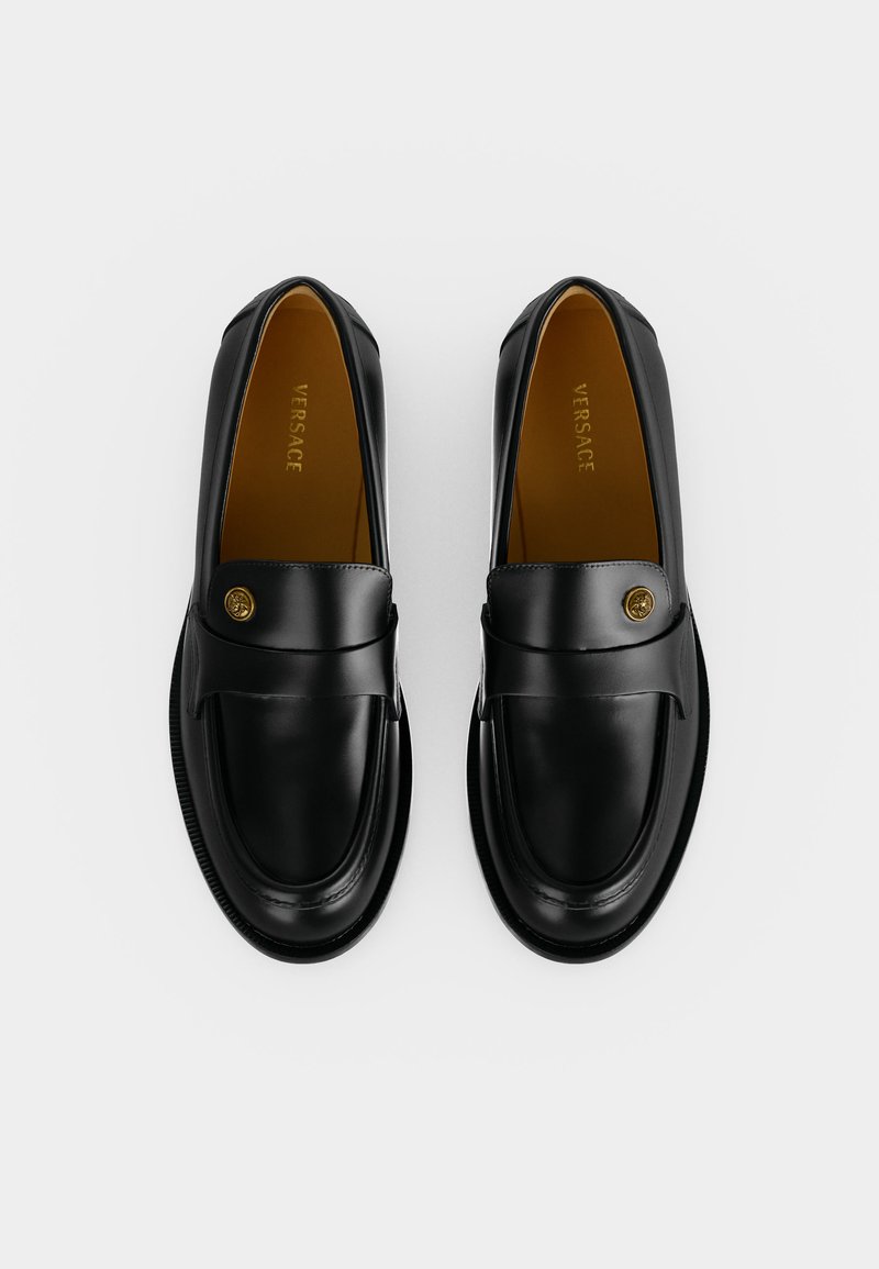 Pair of black leather Versace loafers with gold Medusa buttons, shown from above on a plain white background.