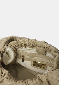 Borsa in pelle intrecciata beige con un'apertura morbida e arricciata, dotata di una fodera in tessuto e una tasca con zip con una piastrina del logo dorato all'interno.