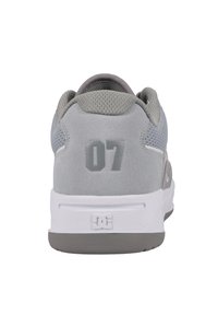 Grå sneaker med en texturerad överdel i mocka och mesh, vit sula och en framträdande grå "07" på hälen. DC-logotyp på sulan.
