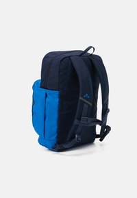 Backpack featuring a two-tone design in navy and blue, made of durable fabric with padded straps and a side pocket for storage.