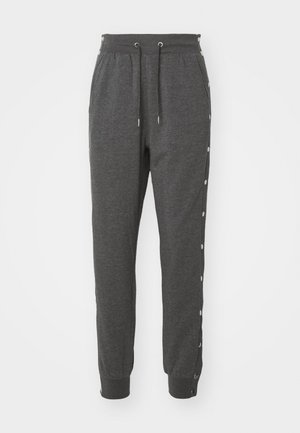Pantaloni della tuta grigi realizzati in tessuto morbido, dotati di una cintura con cordino, polsini alla caviglia e bottoni a pressione lungo i fianchi per un facile accesso.