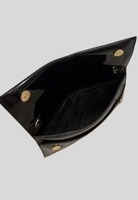 Sac à main en cuir verni noir avec une finition brillante, offrant un intérieur spacieux, du matériel doré et une doublure à motifs.