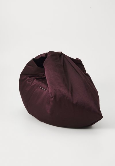 Mörk burgunderröd oversized slouchy tygväska med en samlad öppen topp och en mjuk, rynkad textur på en enfärgad vit bakgrund.