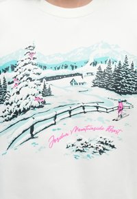 Paisagem montanhosa nevada com um esquiador vestido de rosa, árvores cobertas de neve, uma cerca, uma cabana e um comboio ao fundo rotulado como Jordan Mountainside Resort.