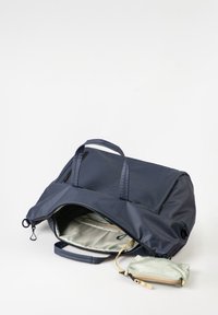Große dunkelblaue Reisetasche mit Reißverschluss, doppelten Griffen, hell gefärbtem Innenraum und einem kleinen abnehmbaren Täschchen. Wasserdichtes Material.