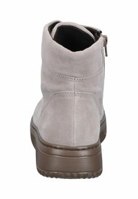 Suède enkellaars in lichtgrijs met een gladde afwerking, bruine rubberen zool en een zijrits voor gemakkelijk aan- en uittrekken. Kenmerkt zich door stiksels.