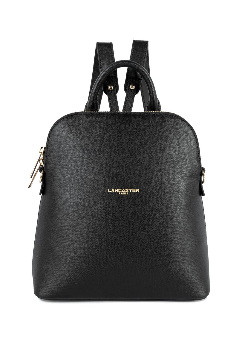 Sac à dos en cuir noir avec des bretelles réglables, un sommet arrondi, une surface texturée, un logo doré et des détails zippés sur le côté.