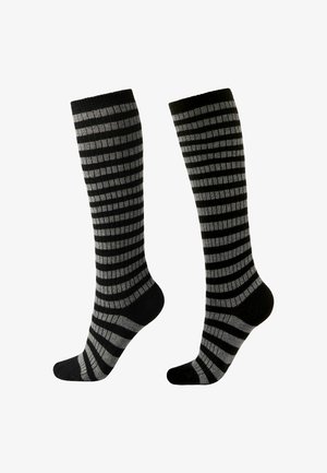 Czarne i szare skarpetki do kolan z paskowanym wzorem, składającym się z naprzemiennych pełnych i wzorzystych sekcji, wykonane z gładkiego, dzianinowego materiału.