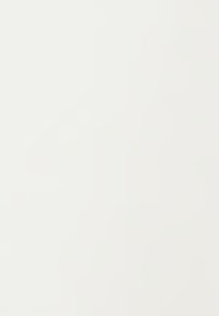 Drie diverse personen werken samen rond een laptop, discussiërend over documenten in een helder, modern kantoor met glazen wanden en uitzicht op de stad.