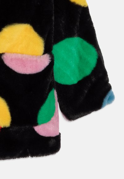 Kurtka z kolorowego sztucznego futra z dużymi kółkami w kolorach żółtym, zielonym, różowym i niebieskim na czarnym tle. Miękka tekstura i krótk design.