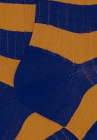 Calzini a righe con colori alternati blu e oro, realizzati in un materiale a maglia testurizzato con un design a costine.