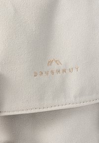 Ljust grå canvas tyg med en texturerad yta och stickade detaljer. Har en präglad "Doughnut"-logotyp ovanför en bergsgrafik.