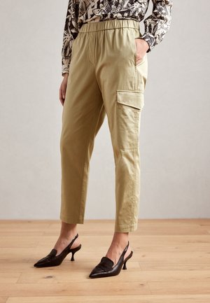 Khaki kalhoty s vysokým pasem a cargo střih, s elastickým pasem, bočními kapsami a manžetami, v kombinaci s černými slingback podpatky.