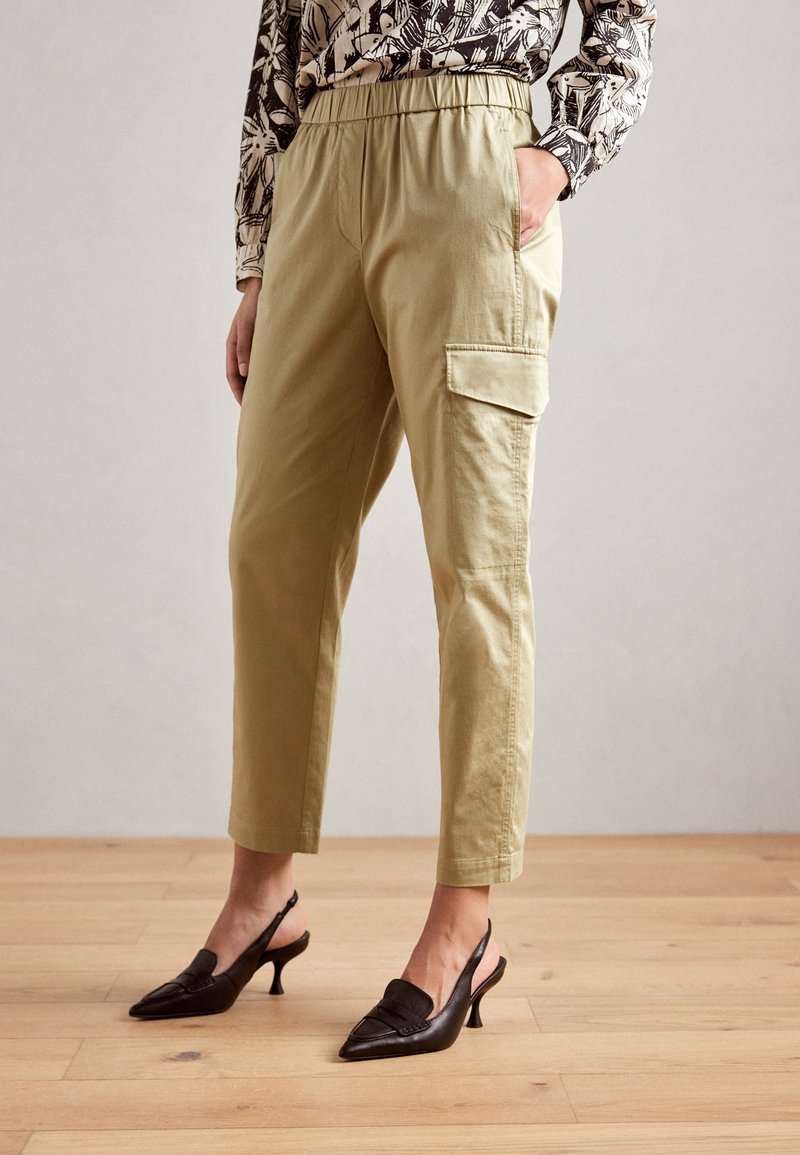 Khaki kalhoty s vysokým pasem a cargo střih, s elastickým pasem, bočními kapsami a manžetami, v kombinaci s černými slingback podpatky.