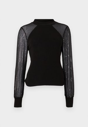 Black long-sleeve top with a high neck, featuring sheer black sequin-embellished sleeves and solid bodice. Ribbed cuffs complete the design.