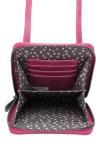 Kompaktowa różowa torba na ramię z zamkiem błyskawicznym; wnętrze wykończone szarym materiałem z różowymi kropkami, z miejscami na karty i podzieloną przegródką.