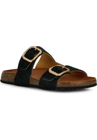 Pantofole in pelliccia nera con due fibbie dorate, suola in sughero, suola piatta e design open toe. Il materiale testurizzato aggiunge interesse visivo.