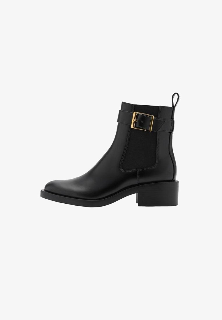 Bottine en cuir noir avec talon bloc bas, bride à boucle dorée, panneau latéral élastique et languette à l'arrière.
