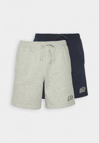 Deux paires de shorts pour hommes : une grise et une marine. Les deux possèdent une taille élastique avec un cordon de serrage et affichent le logo GAP dans des couleurs contrastées.