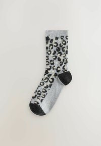 Sive čarape s crnim i bež leopard uzorkom, s crnim prstom i petom. Izrađene od mekog, teksturiranog materijala.