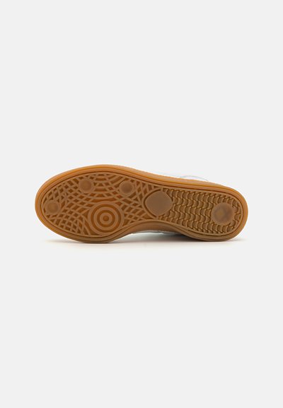 Skoesåle med gummibygging, nøttefarge, teksturert overflate med sirkulære og mønstrede design, som gir grep og holdbarhet.