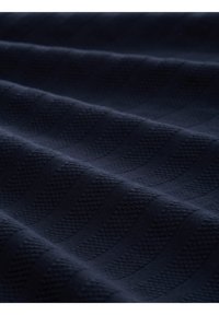 Tejido marino con rayas texturizadas, que presenta un patrón tejido. Textura suave y lisa, con secciones elevadas y planas alternadas.