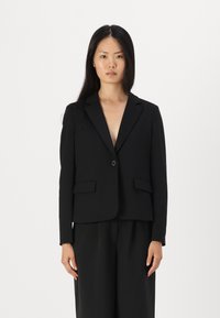 Blazer nero con vestibilità sartoriale, rever a punta, chiusura con un bottone e due tasche frontali, realizzato in tessuto texturizzato.