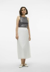 Bezramkowy metaliczny szary top, biały plisowany maxi spódnica i jasne wsuwane buty. Gładka faktura i prosty design.