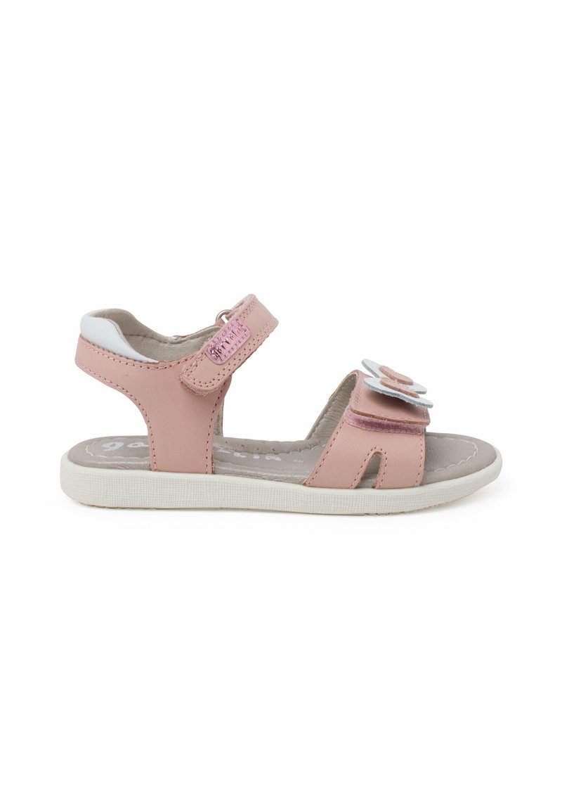 Sandalía de cuero rosa con acentos blancos, tiras de velcro, decoración floral en la parte delantera y suela de goma texturizada.