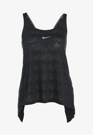 Kobieta ubrana w czarny top Nike i legginsy w lamparcie wzory oraz białe sneakersy Nike stojąca na białym tle.