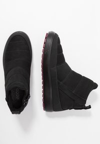 Bottes d'hiver noires avec des semelles texturées, des panneaux cousus et des languettes de tirage, présentées en vues de dessus et de côté sur un fond blanc.