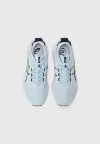 Light blue athletic shoes with a textured upper, contrasting navy accents, and reflective details. Features flat laces and padded collar.