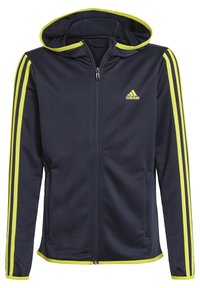 Giacca con cappuccio e zip navy con strisce giallo brillante lungo le maniche e il cappuccio; presenta chiusura con zip e tasche laterali. Realizzata in tessuto liscio.