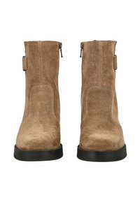 Bottines en daim marron avec une texture lisse, dotées d'une semelle noire robuste et de fermetures éclair sur les côtés pour un enfilage facile.