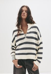 Creme- und marineblau gestreifter Pullover mit halbem Reißverschluss-Kragen, weiten Ärmeln und geripptem Saum; strapazierfähiger Strickstoff mit lässigem Schnitt.