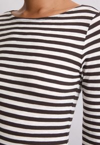 Langarmshirt in bruin en witte strepen, met een ronde halslijn en zachte, rekbare stof. Detail toont de mouw- en schoudernaad.
