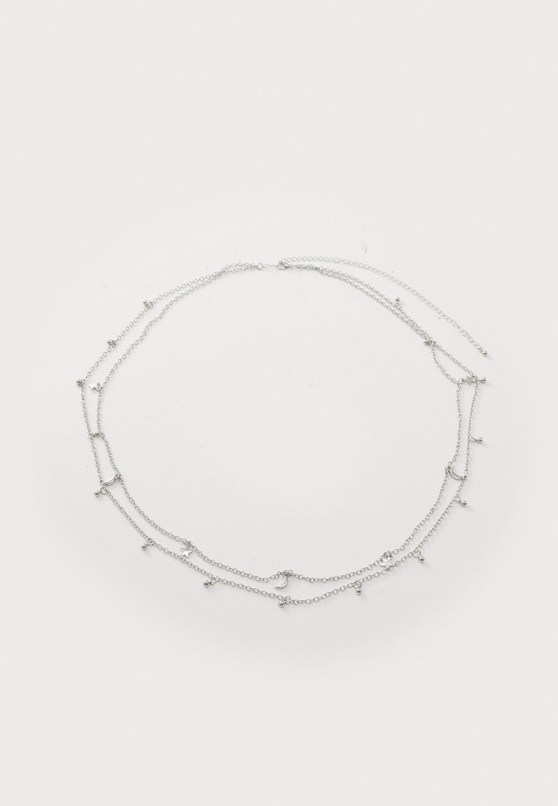 Collana multi-strato in argento con catene fini e piccoli accenti circolari e a forma di stella, creando un design delicato e intricato.