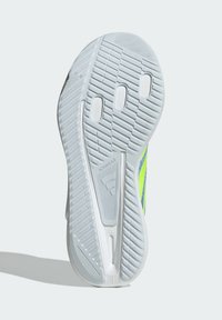 Witte rubberen sneakerzool met een gestructureerde loopvlak, voorzien van een mix van visgraat- en horizontale groeven. Accentkleuren in felgroen en blauw.