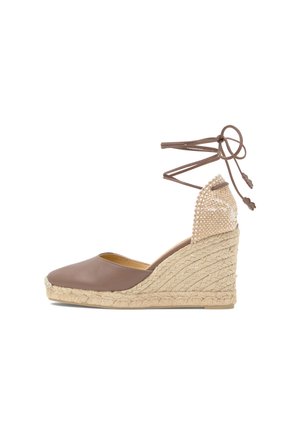 Zapato espadril de cuña marrón con suela de yute trenzada, punta cerrada, detalle beige tejido en el talón y cordones marrones para atar en el tobillo.