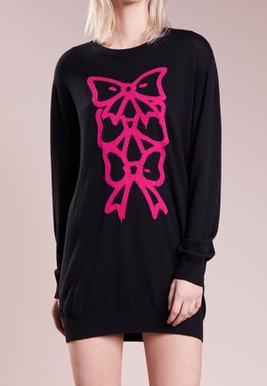 Black sweater dress with long sleeves and ribbed cuffs, featuring a large, bright pink bow graphic on the front. Soft texture.