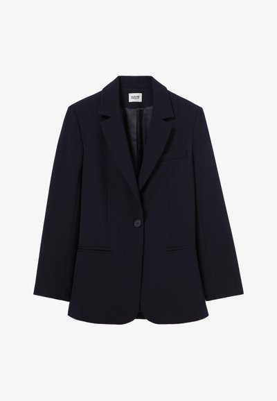 Blazer de un navy oscuro hecho de tela suave. Presenta un cierre de un solo botón, solapas muescas y dos bolsillos frontales con solapas.