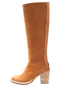 Bota de cuero marrón hasta la rodilla con un acabado texturizado, tacón apilado y un panel lateral contrastante que presenta un detalle de costura horizontal.