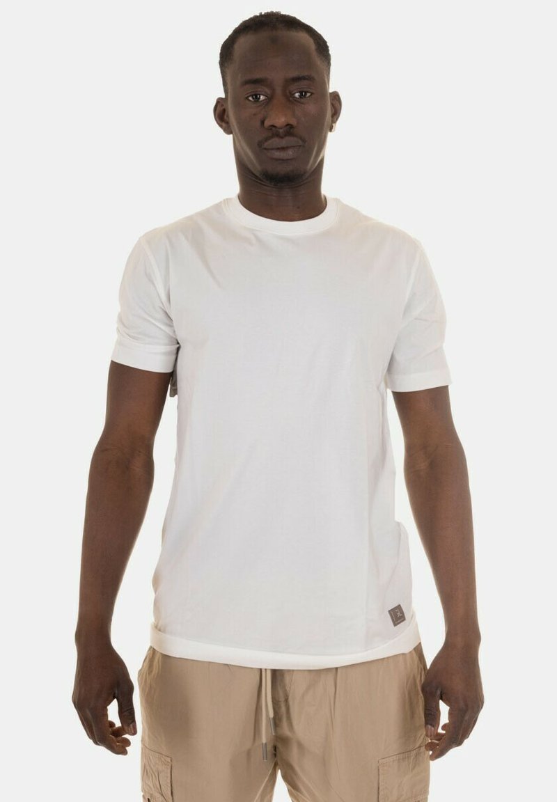 T-shirt bianco a maniche corte realizzato in un tessuto morbido, con scollatura rotonda e una piccola etichetta del logo sul lato inferiore. Tessuto liscio, vestibilità regolare.