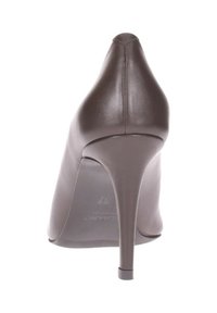 Scarpa con tacco alto in pelle marrone, punta affusolata e tacco a stiletto slanciato, caratterizzata da una texture liscia e un design minimalista.